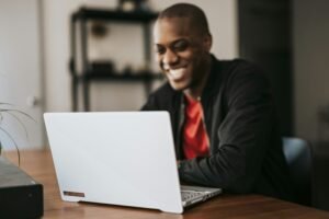 Man smiling in front of his laptop