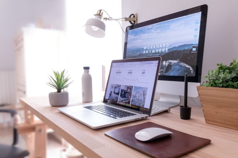 One computer screen with hybrid work trends and another one with "work anywhere" written on the background image
